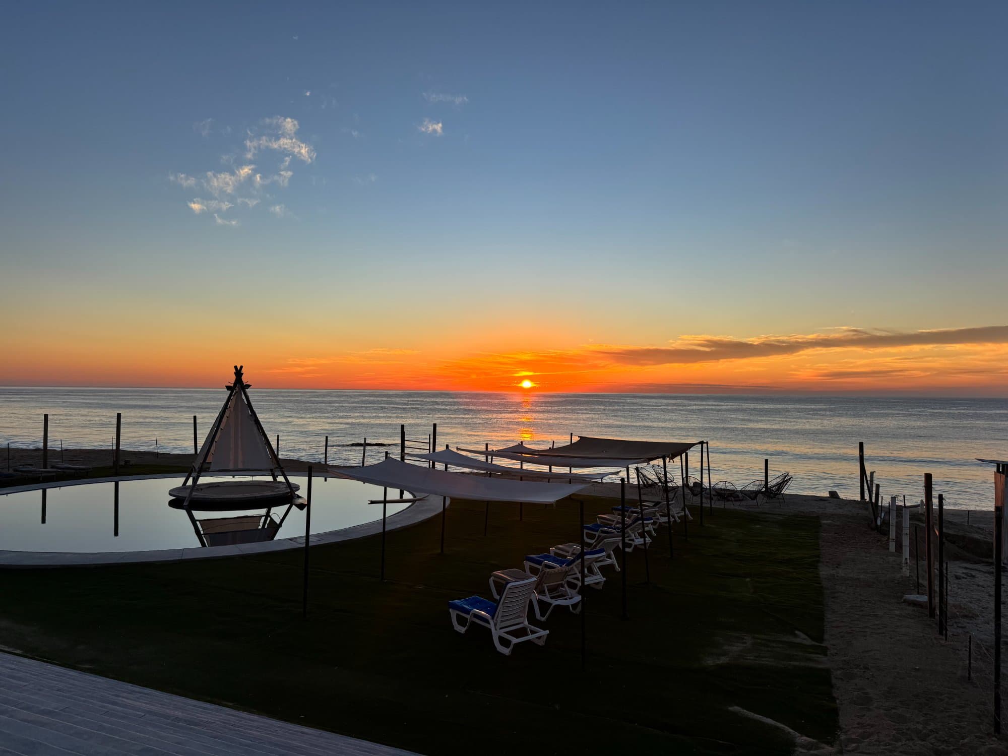 Resort pool with ocean sunset