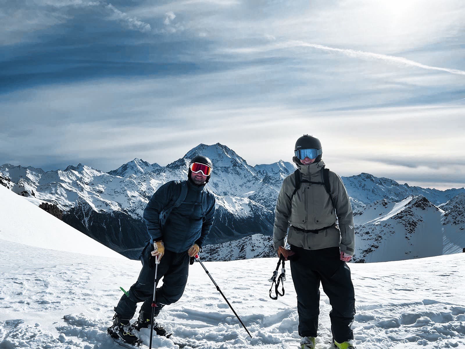 Two skiers on summit with Southern Alps backdrop