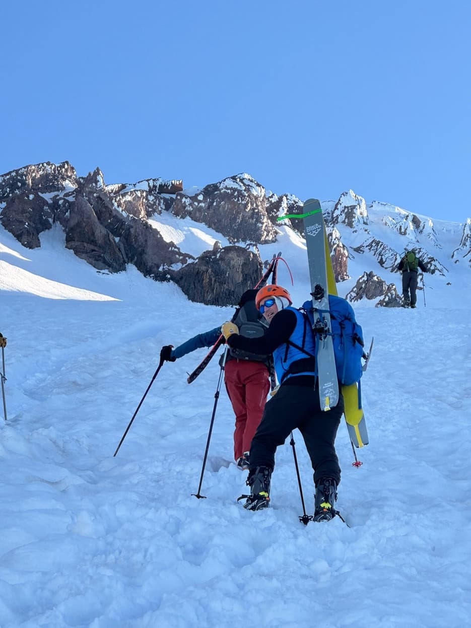 Two skiers skinning up side by side