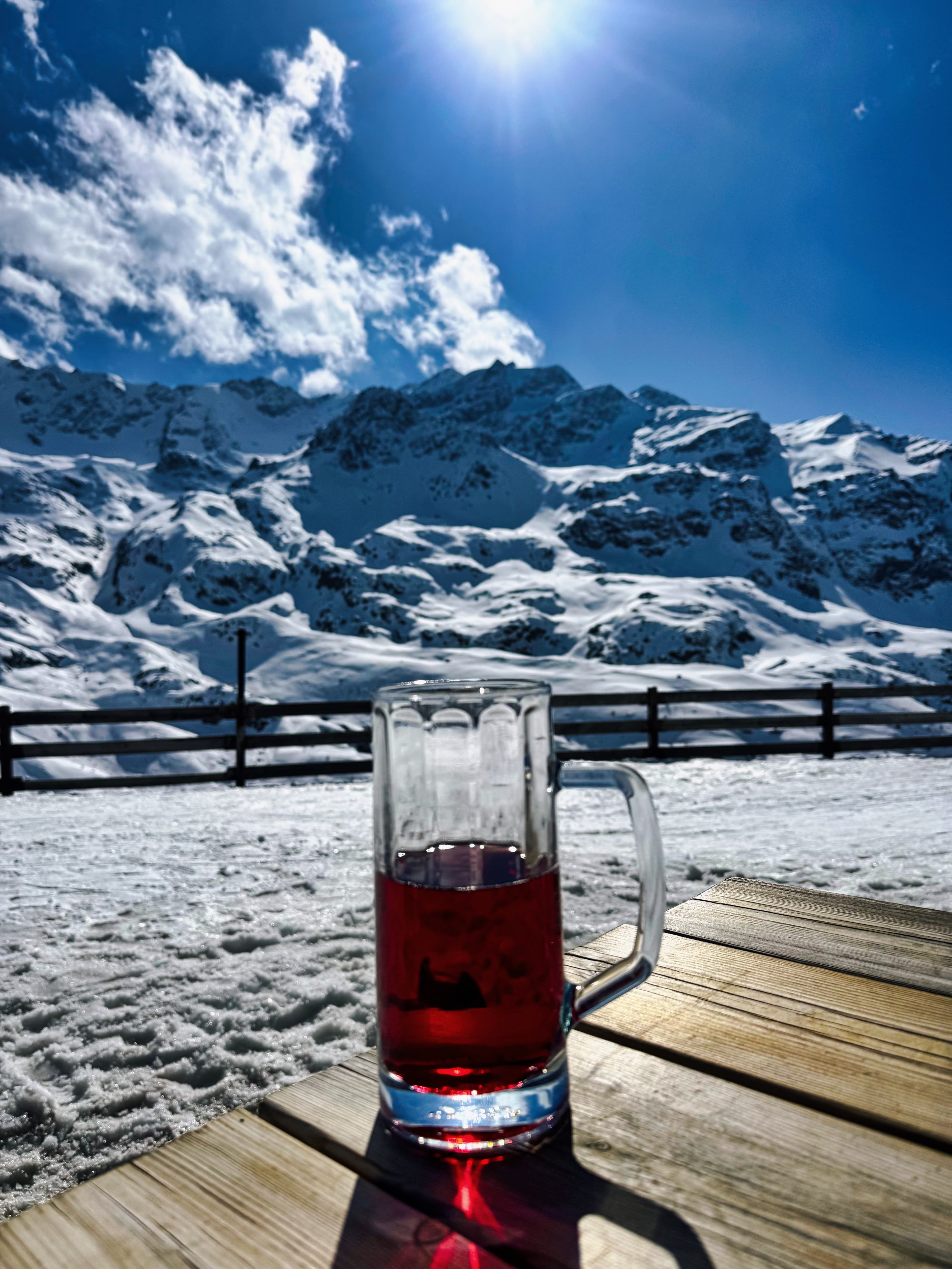 Skiwasser on the deck at Zufallhütte with alpine peaks behind